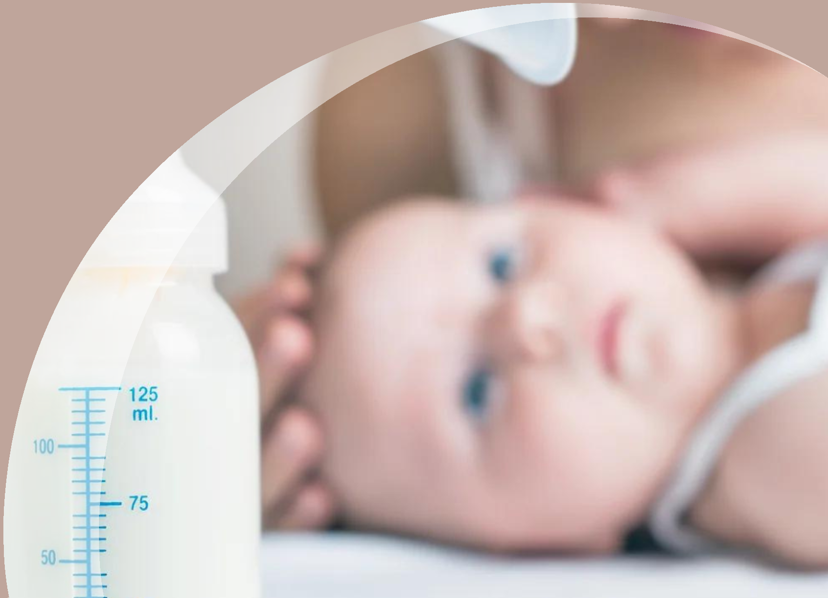 Baby in the background looking at a bottle of breast milk from a breast pump