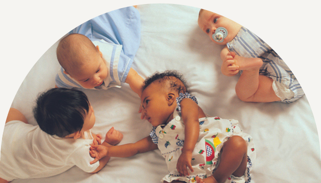 Group of young babies doing tummy time, on the floor, infant milestones concept