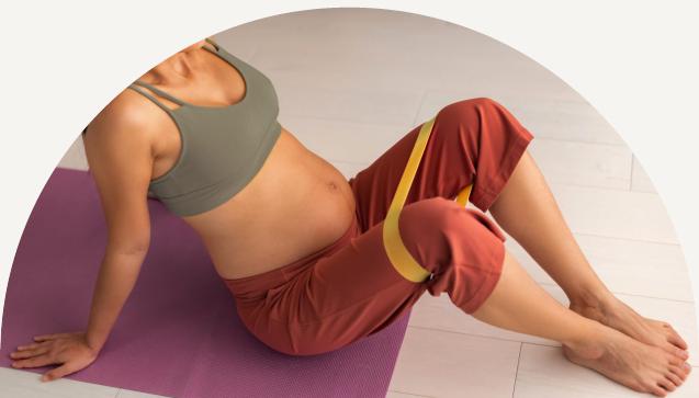 Pregnant woman on a yoga mat doing stretches