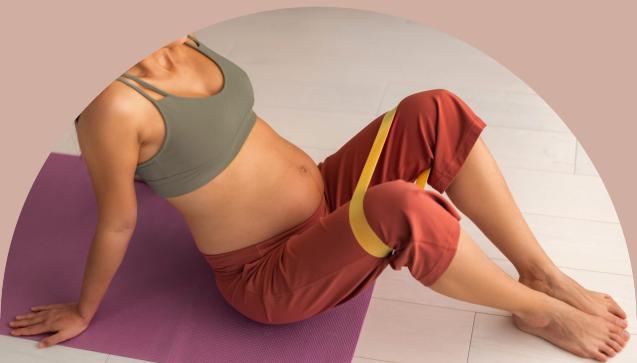Pregnant woman on a yoga mat doing stretches
