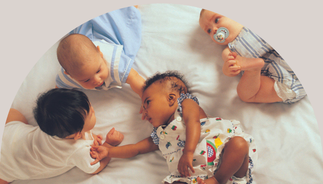 Group of young babies doing tummy time, on the floor, infant milestones concept